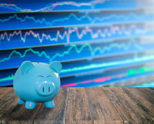 Blue Pig Bank On Wood Background With Blur Stock Market Backgrou