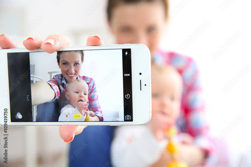 Young mother taking a selfie with her baby, close up