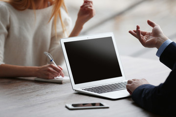 Poster - Businessman using laptop and young woman taking notes