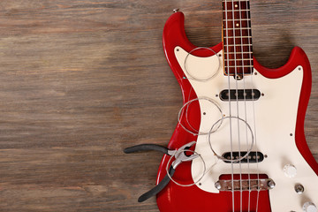 Wall Mural - Electric guitar with pliers and strings on wooden background