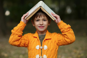 Wall Mural - funny boy with book on his head