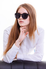 Cute blonde keeps the sunglasses in the Studio on a white backgr