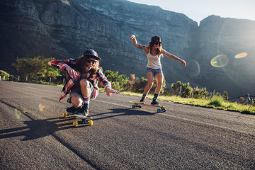 Happy young friends having fun with skateboard