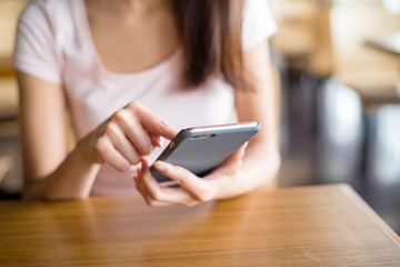 Woman using mobile phone inside cafe