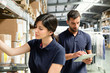 © Connect Images - Warehouse workers using digital tablet to prepare order in distribution warehouse