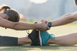 © Connect Images - Two friends warming up to exercise together outdoors