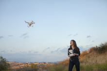Female Commercial Operator Flying Drone Looking Up Smiling, Santa Clarita, California, USA