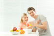 © ZoneCreative - Young casual couple have breakfast with coffee and fruit with venetian blind window