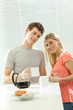© ZoneCreative - Young casual couple have breakfast with coffee and croissant with venetian blind window