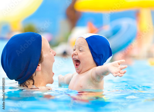 Fotografía Feliz niño y la madre con el casquillo de la piscina se divierten en una piscina