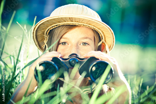 Fotografía beautiful young explorer girl with hat and binocular at park