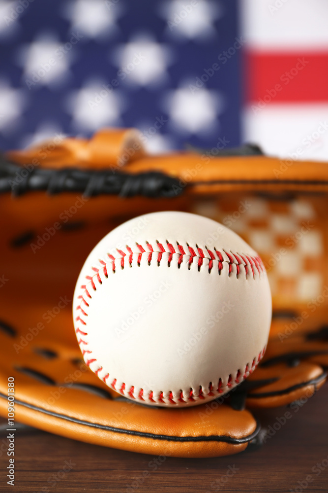 Baseball in glove in front of American state flag