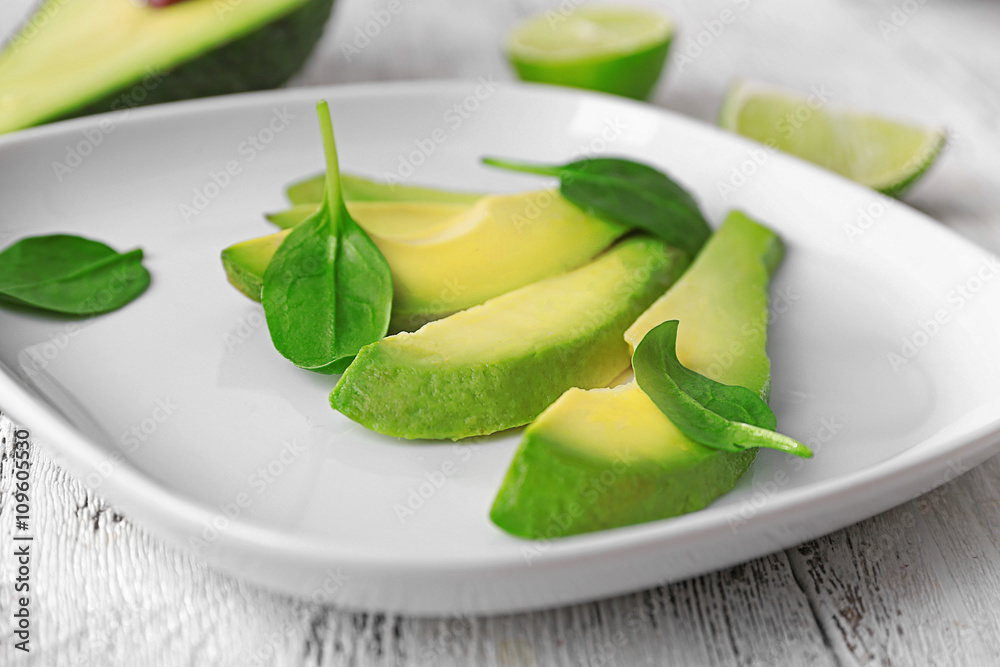Slices of fresh avocado on plate closeup