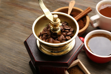 Wall Mural - Coffee mill with roasted beans on wooden table closeup