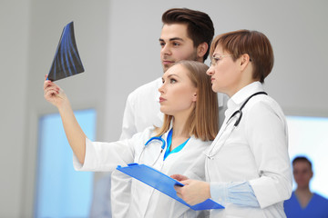 Wall Mural - Three doctors examining x-ray in the hospital