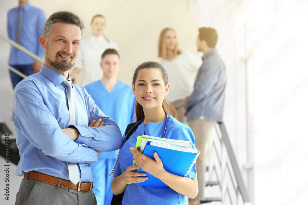 Young female medical student and professor standing indoors