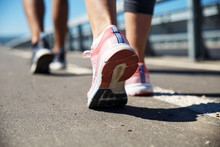 Feet Of An Athlete Couple Running On A Pathway Training For Fitness And Healthy Lifestyle.
