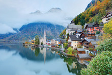 Early Morning View Of Hallstatt With Reflections On Smooth Lake Water, A Lakeside Village In Salzkammergut Region Of Austria, In The Colorful Autumn Season