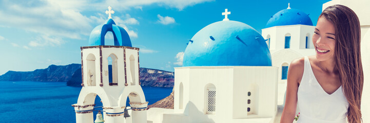 Fototapete - Europe tourist travel woman panorama banner from Oia, Santorini, Greece. Happy young woman looking at famous blue dome church landmark destination. Beautiful girl visiting the Greek islands.
