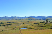 Drakensberg Mountains With Grass And Trails And Blue Sky