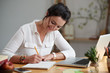 © DragonImages - Smiling business woman writing down her ideas