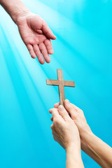 Jesus hand and cross on blue background