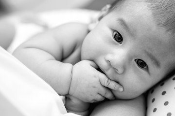asian baby sucking his fingers