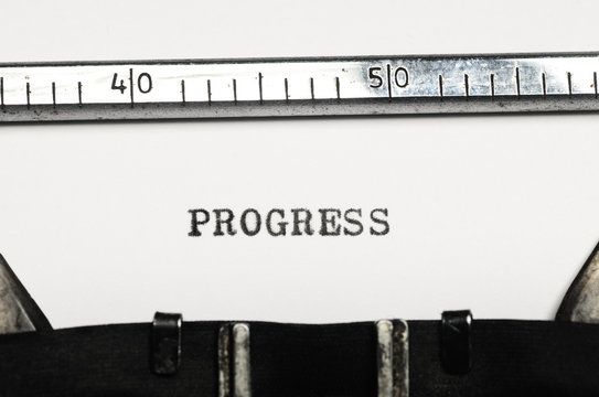 word progress typed on  typewriter
