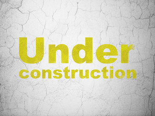 Web development concept: Under Construction on wall background