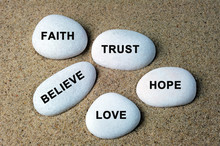 Faith, Trust, Believe, Hope And Love Text On A Stones With Sand Background