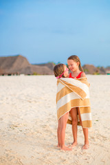 Wall Mural - Little girls wrapped in towel after swimming at tropical beach