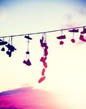 Vintage Toned Silhouettes Of Shoes Hanging On Cable At Sunset, Teenage Rebellion Concept.