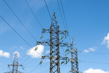 Electric pylons against the backdrop of the blue sky on a summer day