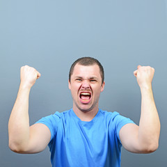 Wall Mural - Portrait of ecstatic young man celebrating victory or win agains