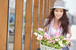 © ZoomTeam - stylish woman in gray hat on a bicycle with spring flowers on a