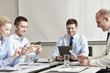 © Syda Productions - smiling business people with gadgets in office
