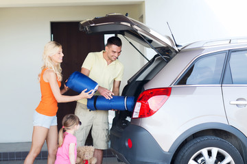 Canvas Print - happy family packing things to car at home parking