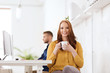 © Syda Productions - happy woman drinking coffee or tea at office