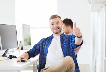 happy creative man with computer at office