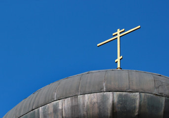 Dome and cross of a russian orthodox church on blue sky background