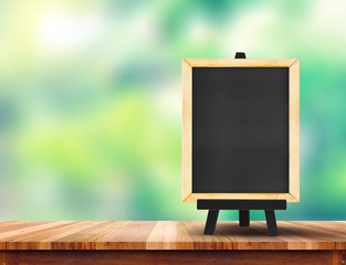 Aufkleber - Blank blackboard on wood table top with sun and blur green tree