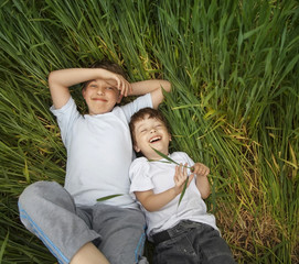 two happy boy lay in grass