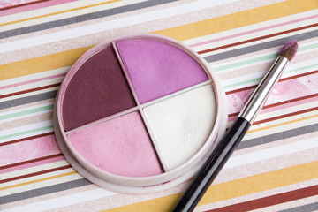 Beautiful bright eye shadows, makeup, pencil sharpener, brush on a bright coloured background,  soft bedding colors, close up