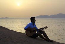 Musician On The Beach Playing Guitar