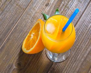 Wall Mural - Fresh orange juice with ice  on wooden background