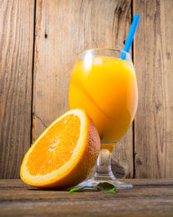 Wall Mural - Fresh orange juice with ice  on wooden background