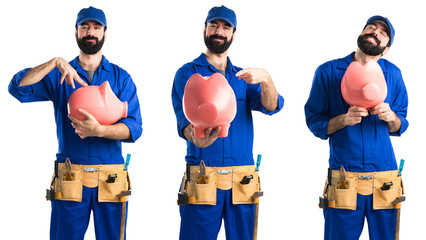 Wall Mural - Plumber holding a piggybank