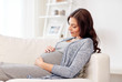 © Syda Productions - happy pregnant woman lying on sofa at home
