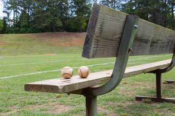 Wall Mural - Baseball on a bench in a little league field