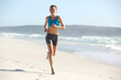 © mimagephotos - Young sportswoman jogging along the seashore